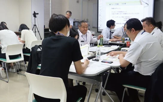 会議室で複数の参加者がグループ討論を行っている様子
