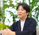 笑顔で斜め上を見ながら話している様子の男性