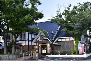 緑豊かな木々に囲まれた、特徴的なハーフティンバー様式の建物