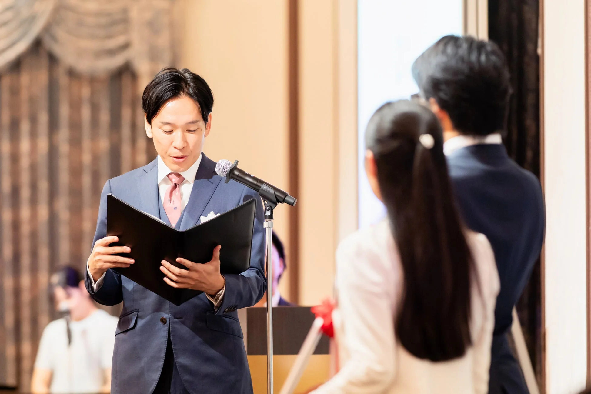 マイクの前でスピーチする男性