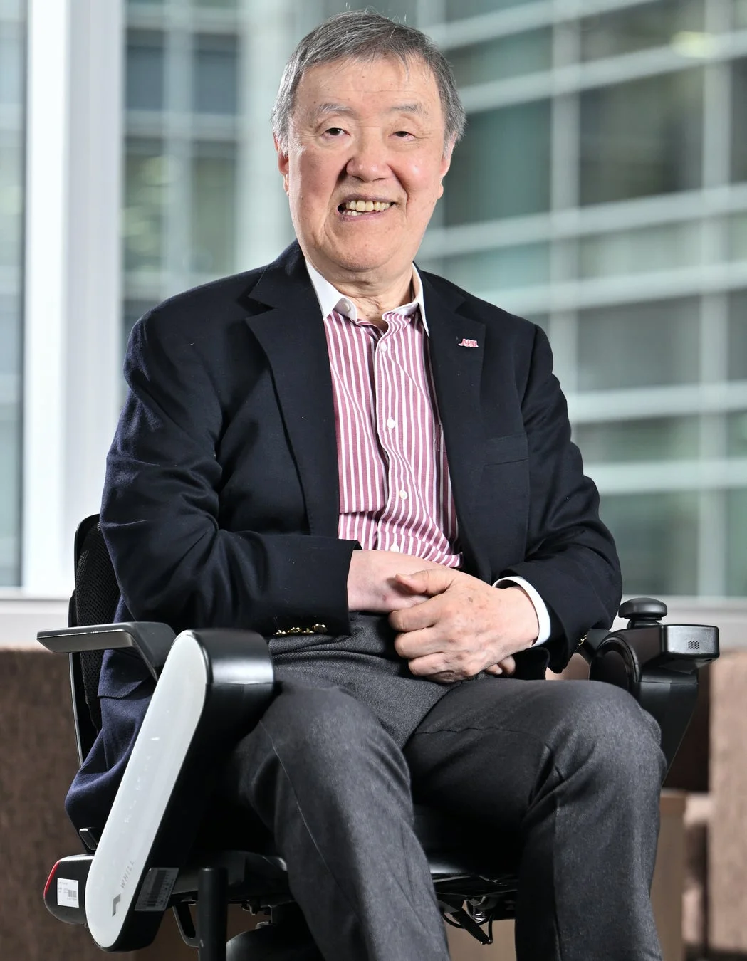 車椅子に座り笑顔の出口治明氏