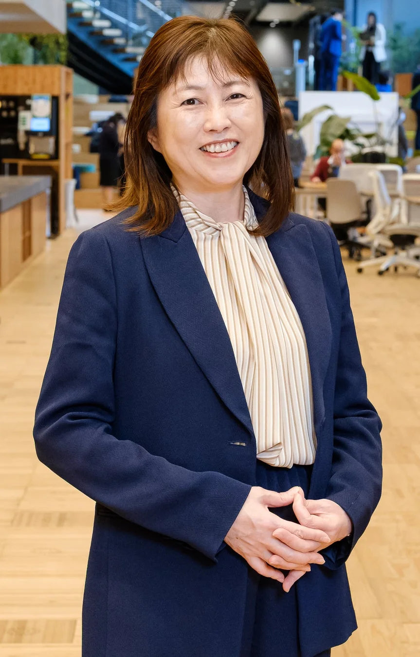 笑顔で立つ西岡真帆氏