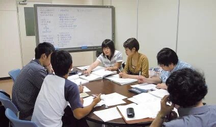 男女が円卓を囲み議論や学習をする様子