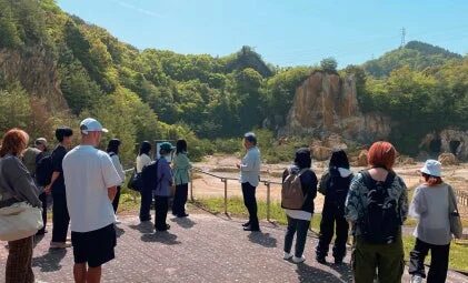 ガイドが屋外でグループに説明をしている様子