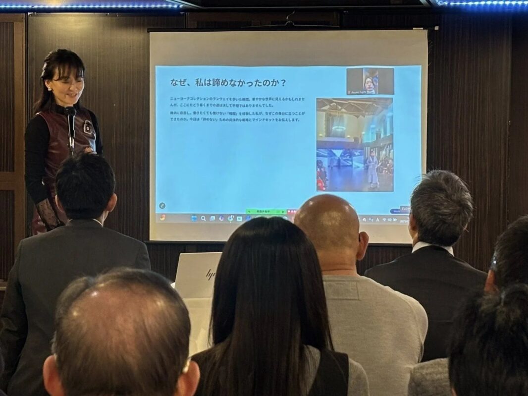 女性がプロジェクターを使って講演を行っている様子。