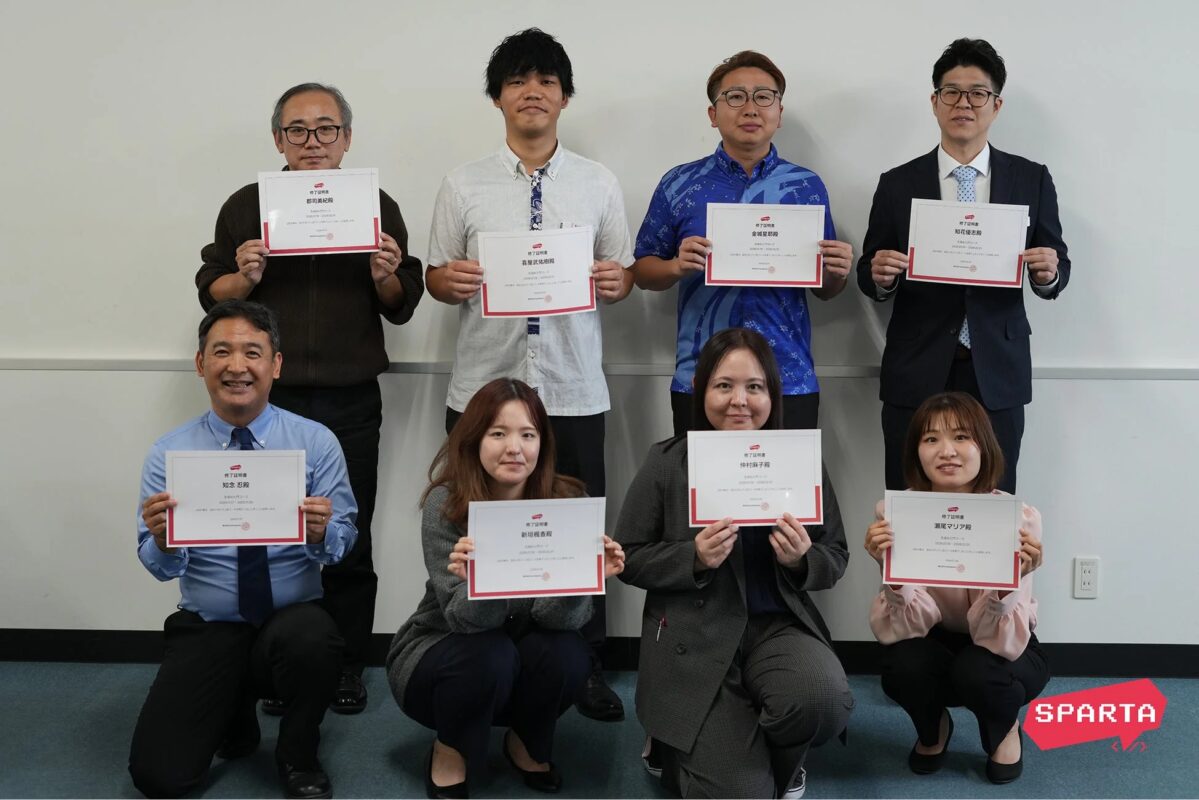 研修修了証を持つ参加者の集合写真